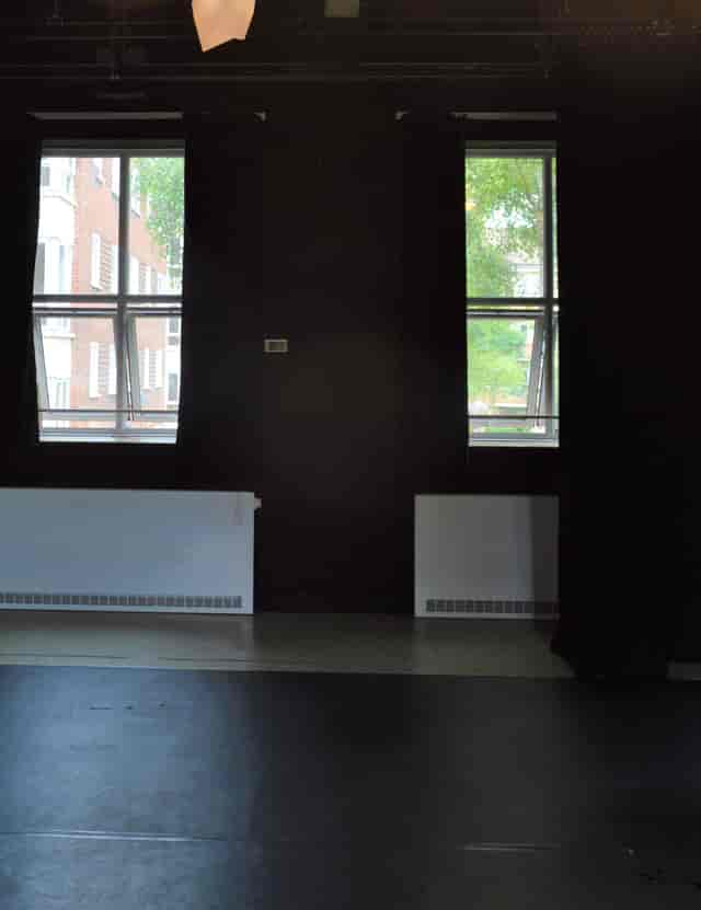 Cozy event space with large windows at Little Angel Studios for meetings and workshops.