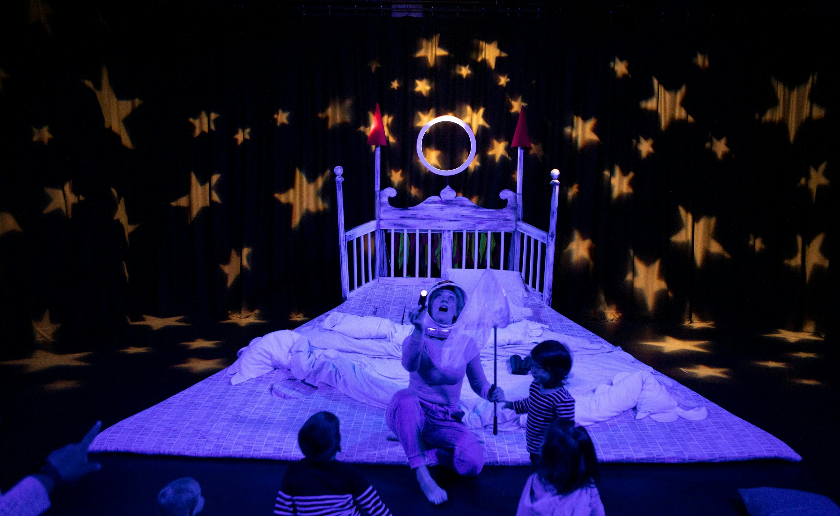 Whimsical children's event stage with starry projections and interactive performer.