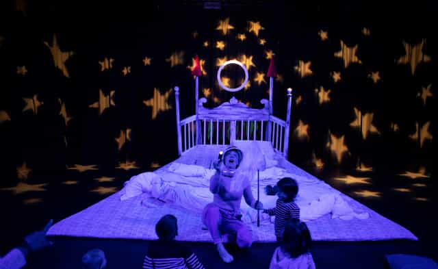 Whimsical children's stage with starry projections for family-friendly events.