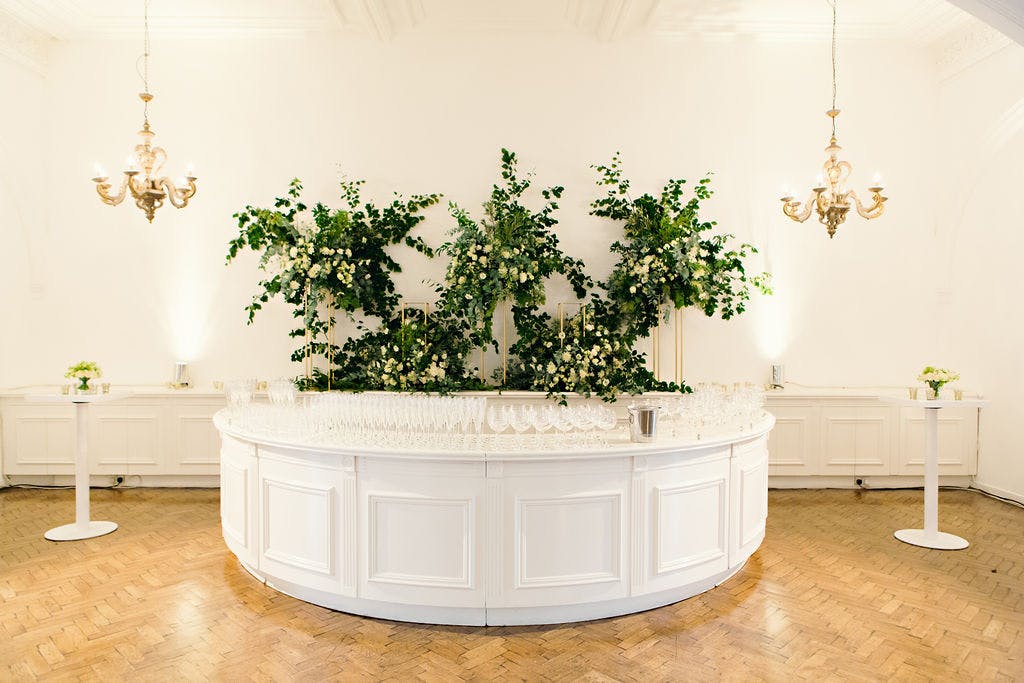 Elegant event space at One Marylebone with lush greenery and stylish bar setup.