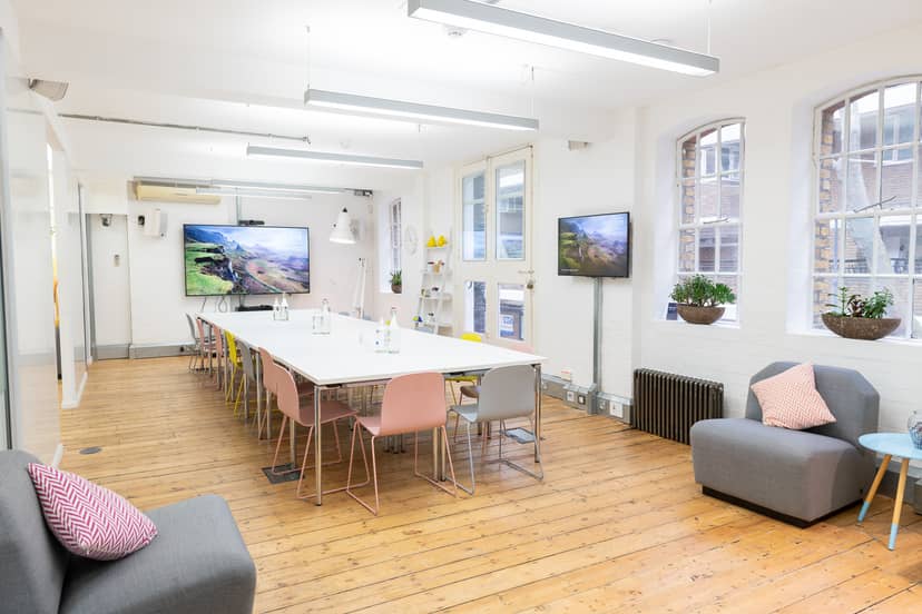 Modern meeting space with long white table for collaboration and creativity events.