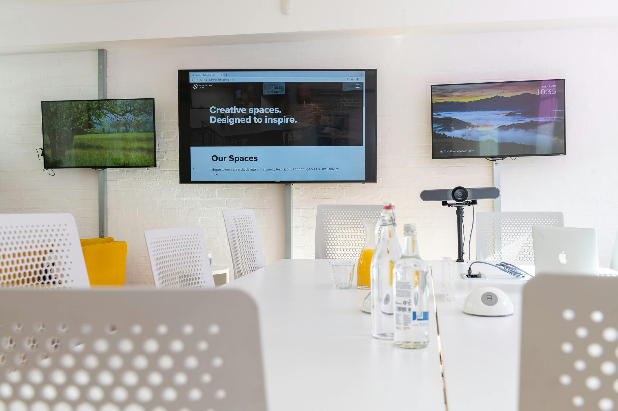 Modern meeting room with screens, natural light for productive collaboration.