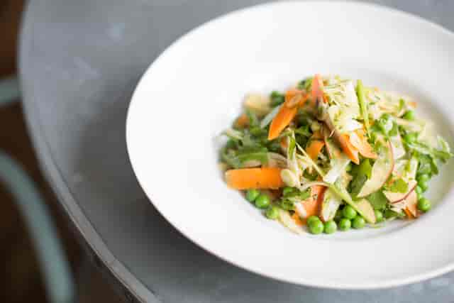 Vibrant salad on white plate for healthy catering at networking lunches and events.