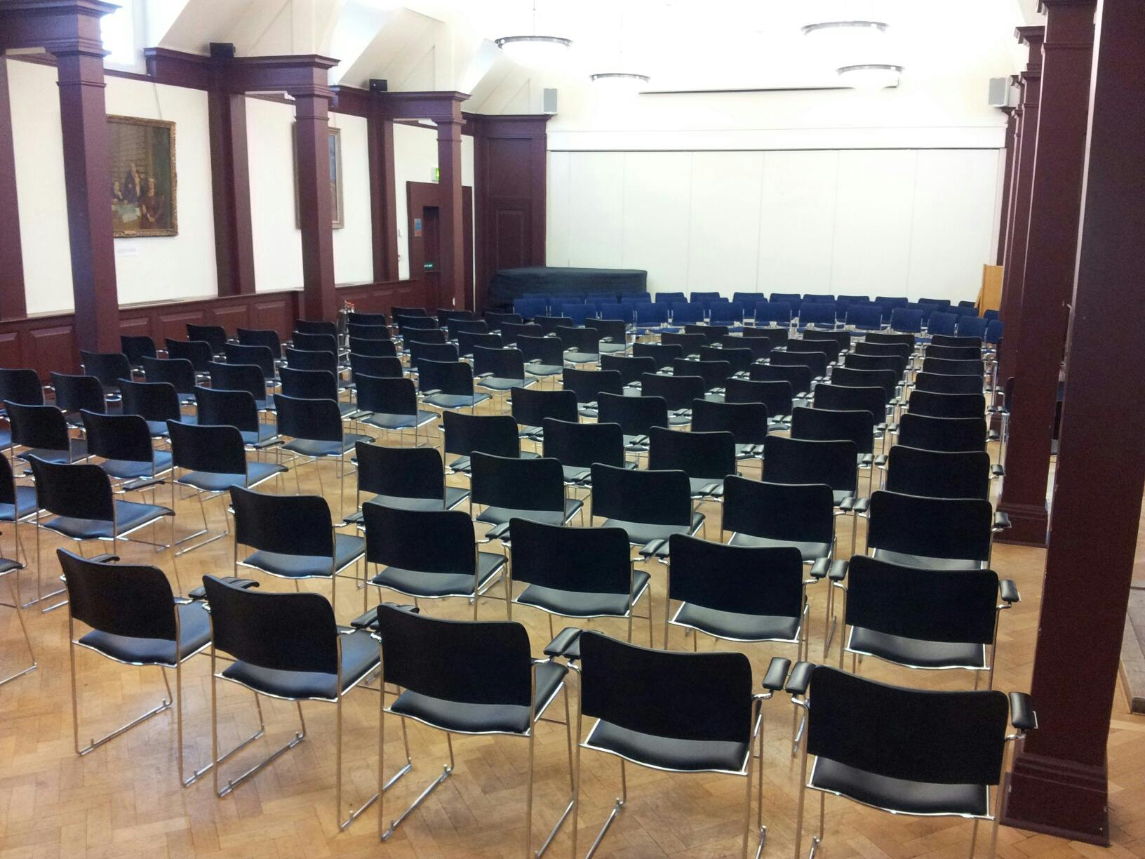 Mordan Hall at St Hugh's College, elegant meeting space with black chairs for lectures.