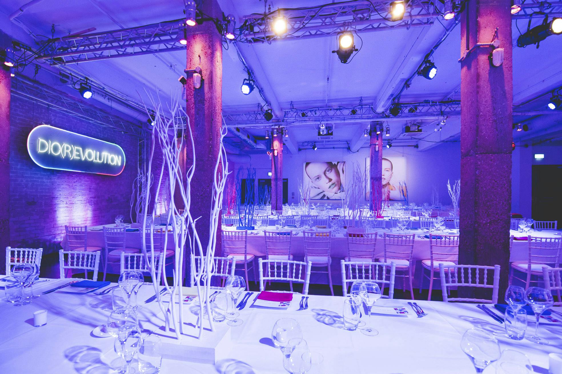 Stylish event space with elegant table settings and purple lighting for branding events.