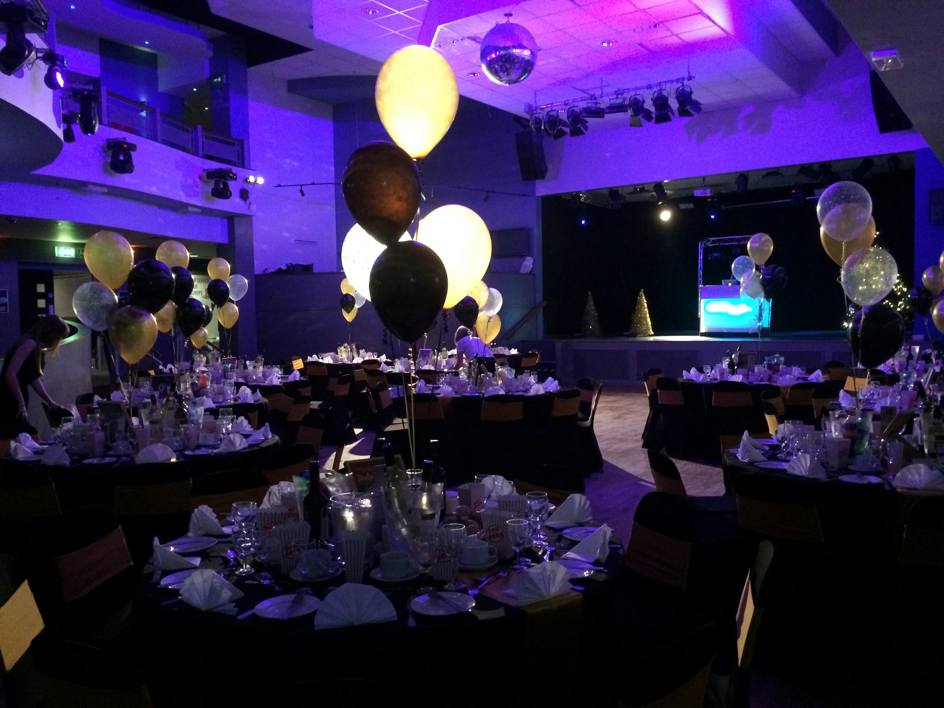 Elegant gala event space at Reading University with black and gold decor and disco ball.