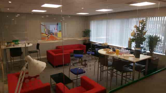 Modern kitchen meeting space with red couches for collaboration and networking events.