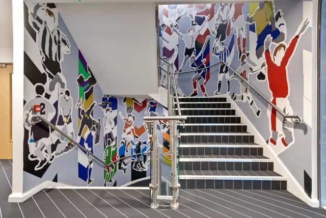 Vibrant athlete mural at Players Lounge, Hotel Football - perfect for events and networking.