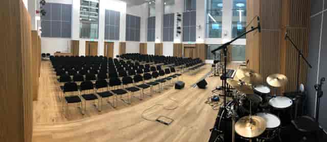 Westbourne Park Baptist Church auditorium with black chairs, ideal for conferences and performances.