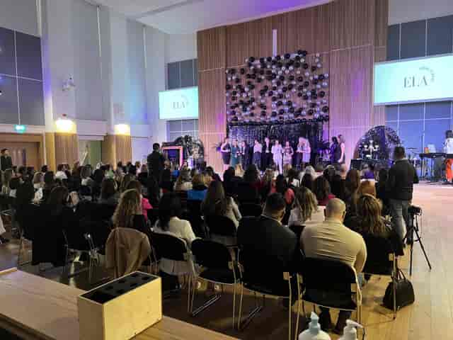 Westbourne Park Baptist Church auditorium during a lively presentation event with multimedia setup.