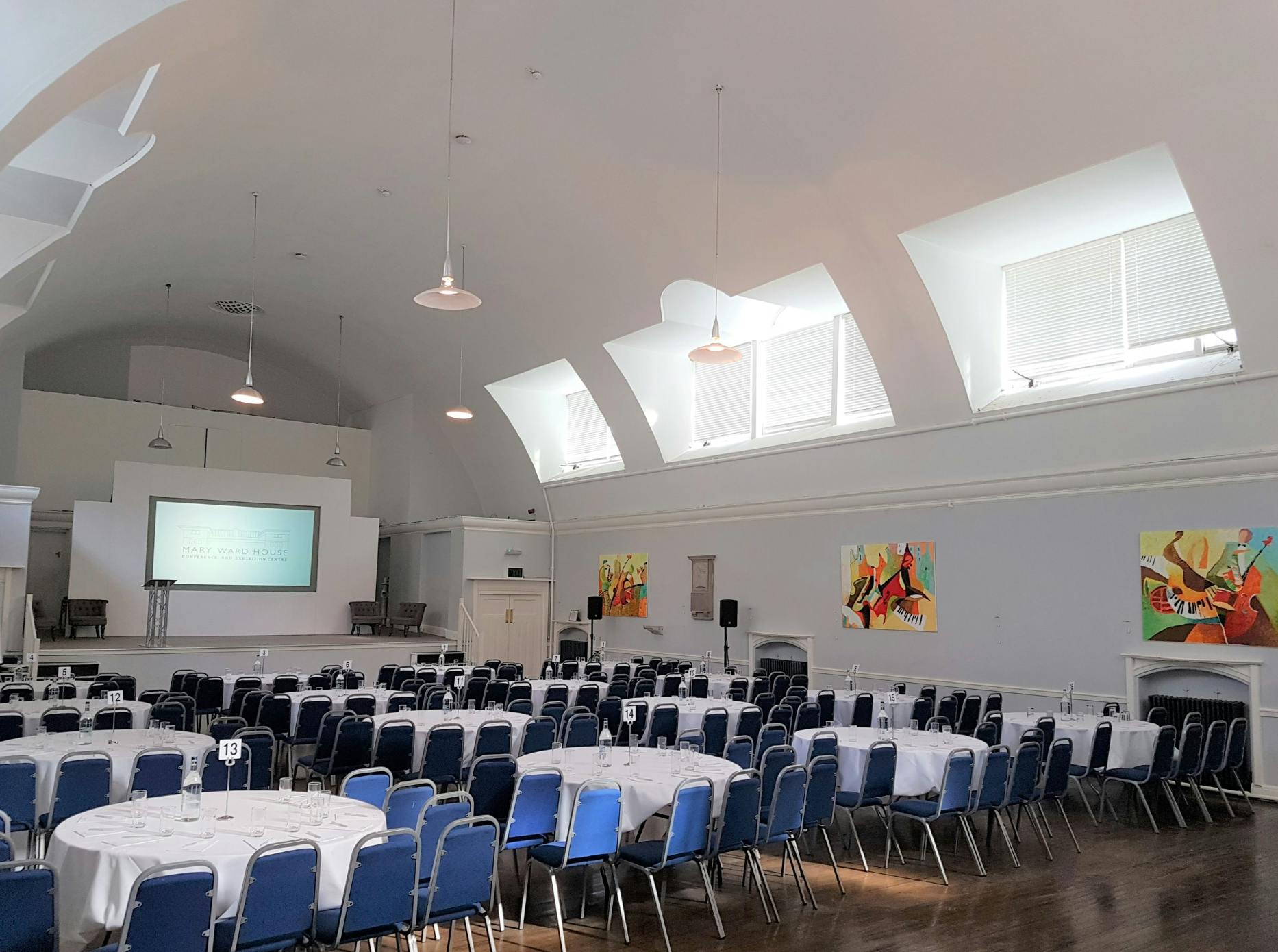 Mary Ward Hall event venue with round tables, ideal for meetings and creative gatherings.