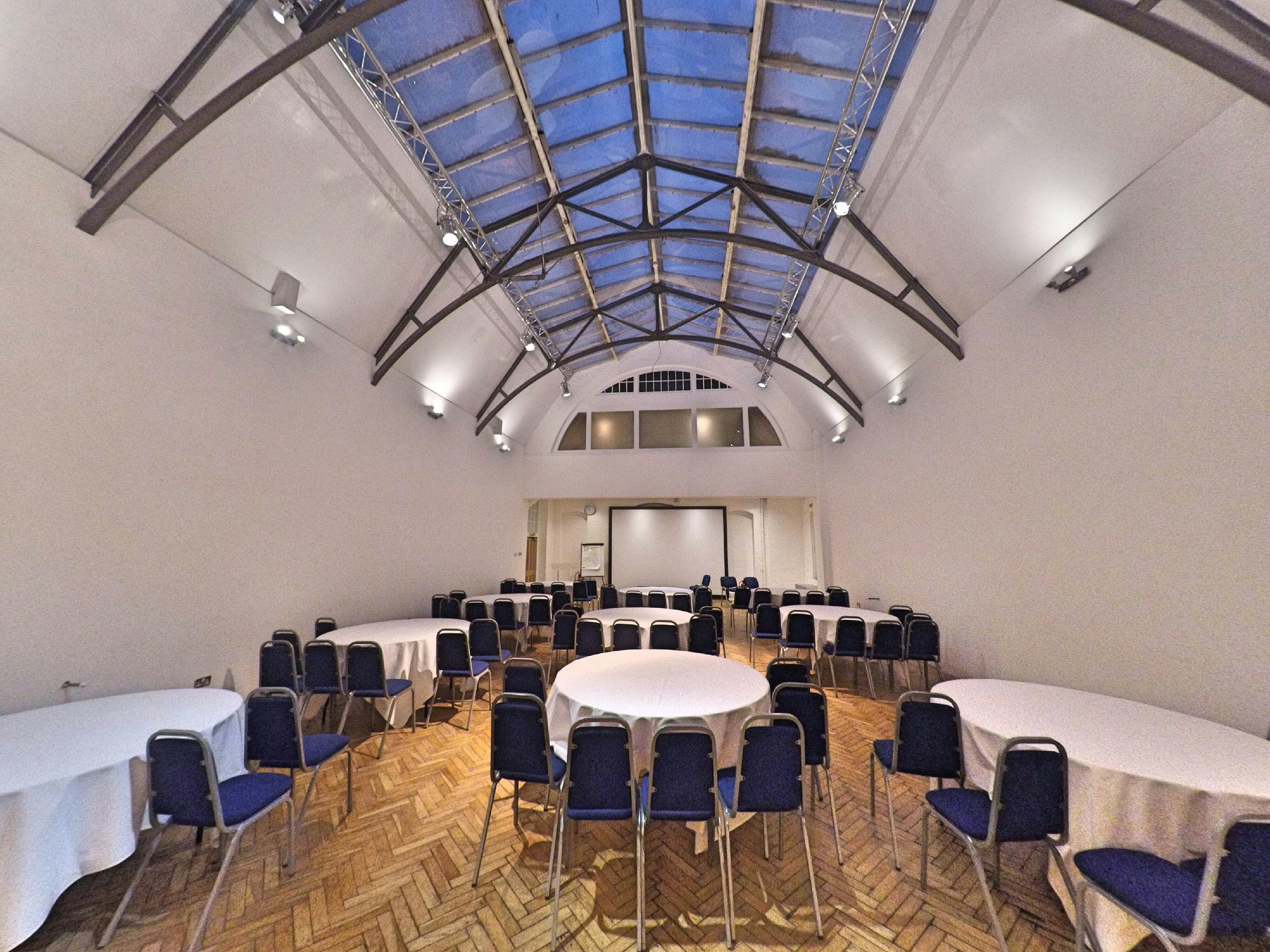 Spacious event venue with high ceilings, ideal for conferences and workshops.