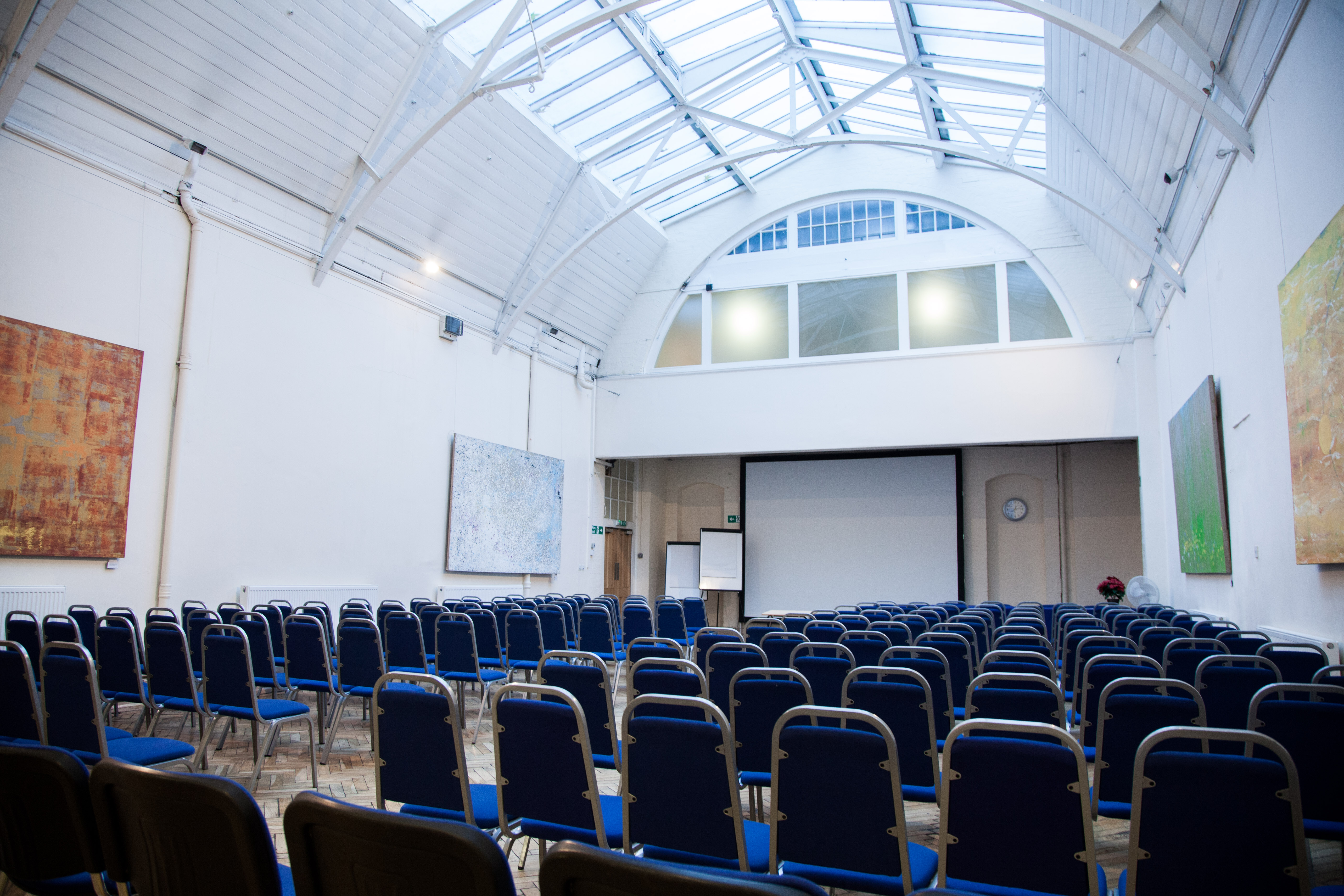 Spacious event venue with blue chairs, ideal for conferences and workshops. - Banner