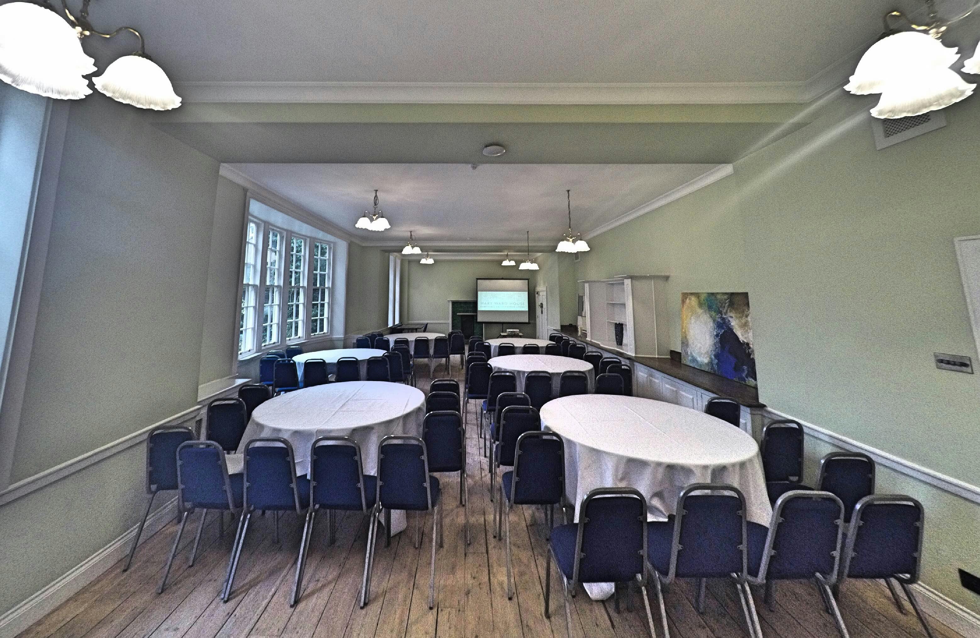 Lethaby Room at Mary Ward House, set for workshops with round tables and blue chairs.