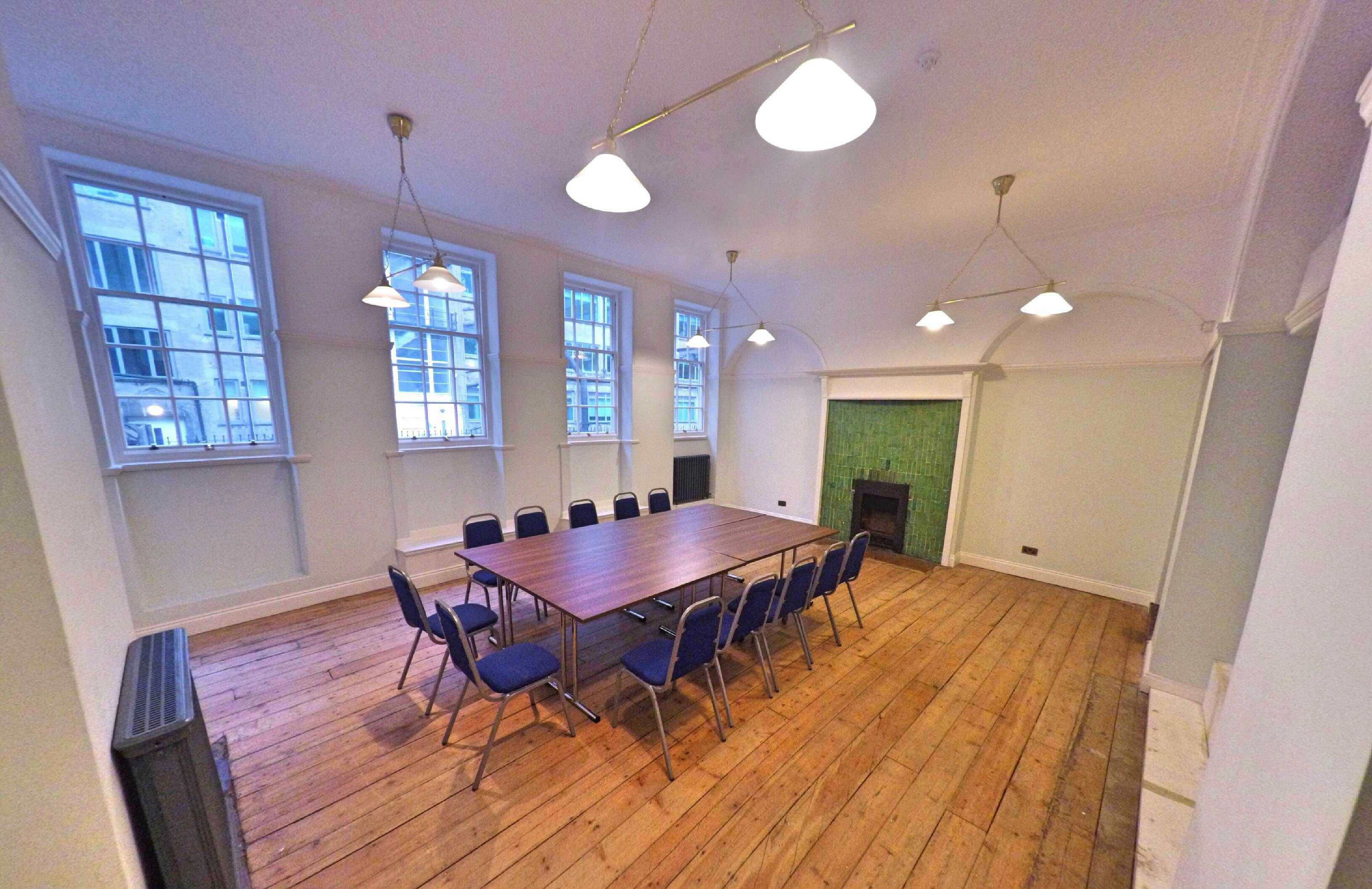 Emerson Room at Mary Ward House: bright meeting space with large table and blue chairs.