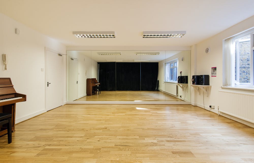 Versatile event space with polished wooden floor, ideal for workshops and gatherings.