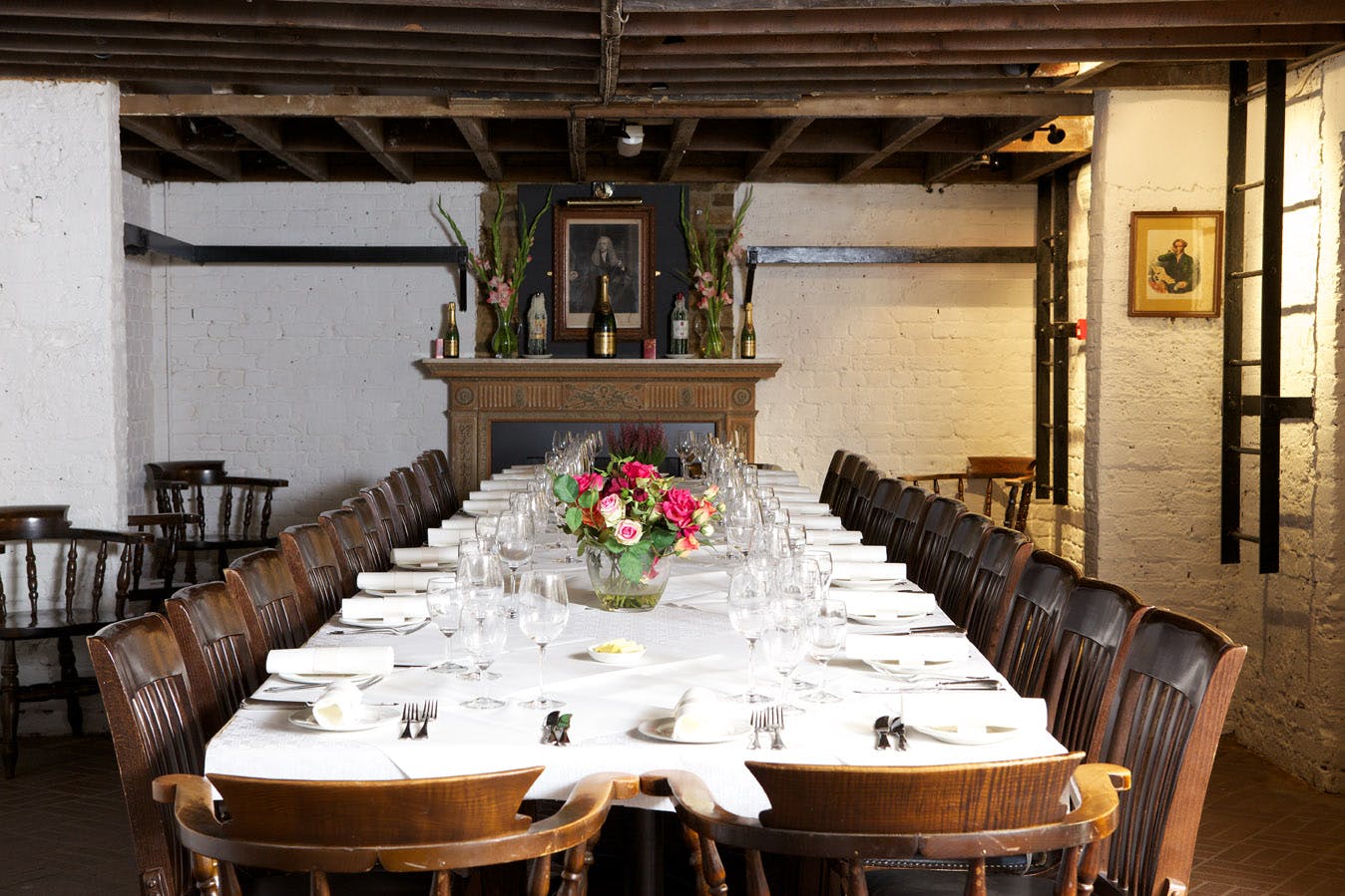 Elegant long dining table with floral centerpiece in rustic venue for intimate gatherings.