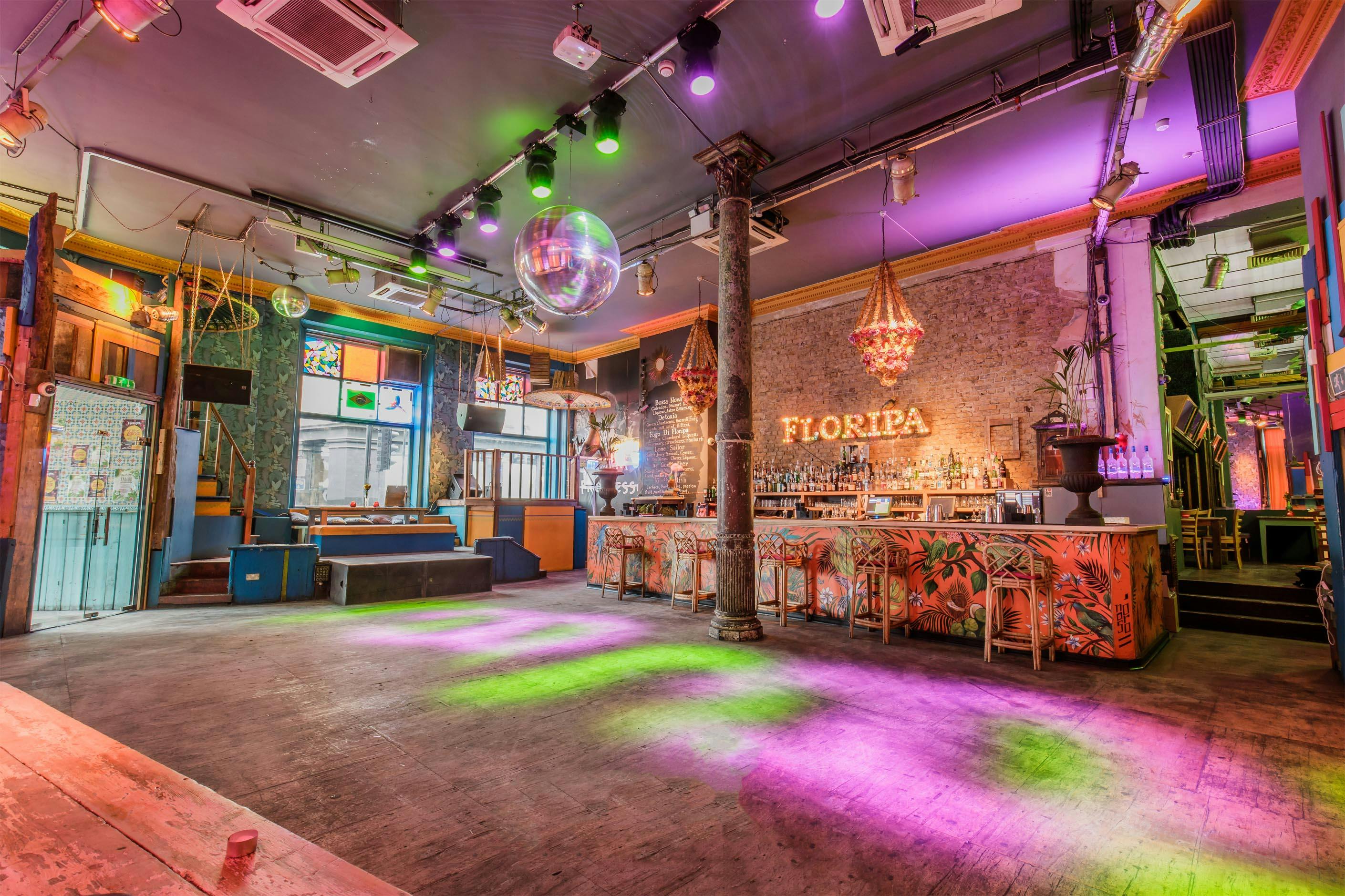 Vibrant event space in Floripa with colorful lighting, ideal for parties and networking.