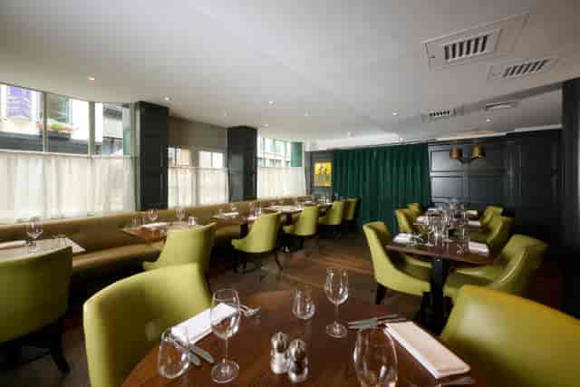 Stylish restaurant venue with green accents, ideal for corporate lunches and small events.