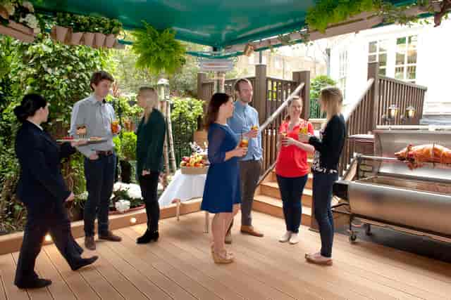 Outdoor event setup at Beach Bar, featuring lush greenery and roast for networking.