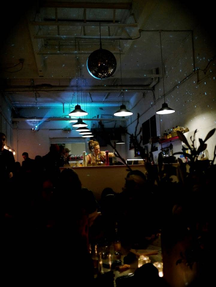 Vibrant cafe event space with stylish lighting, ideal for gatherings and networking.