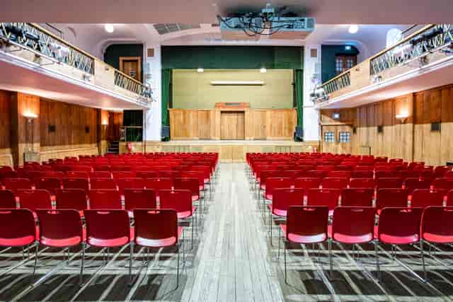 Main Hall in Conway Hall with red chairs, ideal for conferences and presentations.