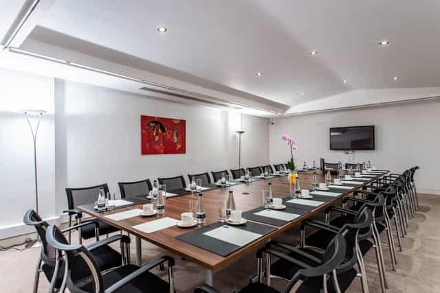 Conference room in Adam House with polished table, ideal for meetings and presentations.