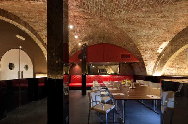 Modern event space with exposed brick arches, ideal for corporate events and private dinners.