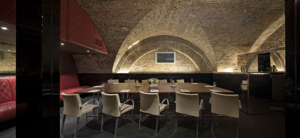 Stylish meeting room with arched brick ceiling, ideal for corporate events and brainstorming.