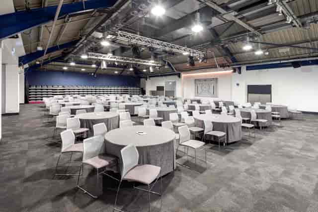 Spacious Business Design Centre auditorium set for a conference with elegant tables and chairs.
