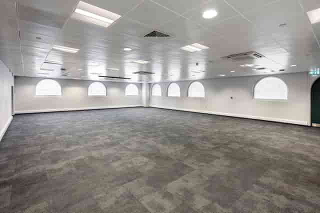 Versatile event space with arched windows, perfect for meetings and workshops.