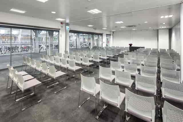 Meeting room with white chairs and natural light for seminars and corporate events.