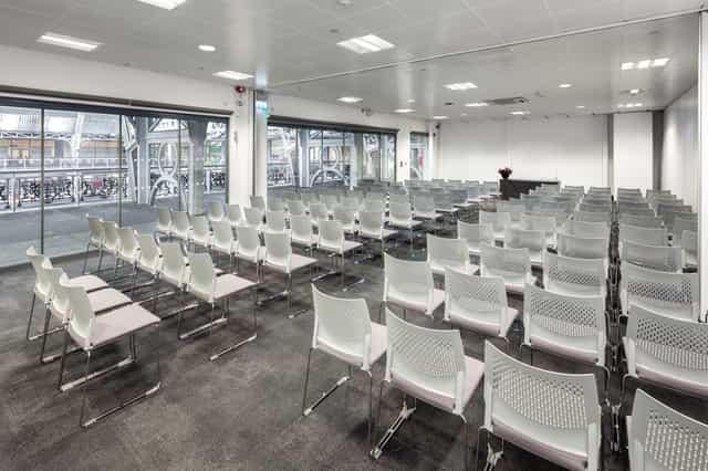 Meeting room with white chairs and natural light for seminars and corporate events.