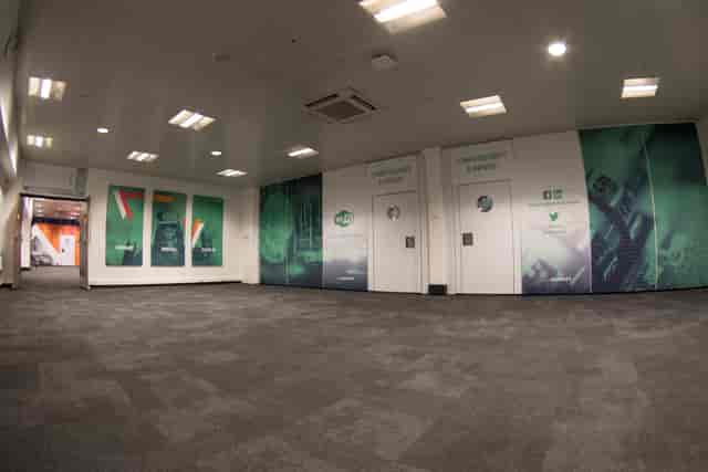 Spacious event space with branded wall graphics for corporate meetings and conferences.