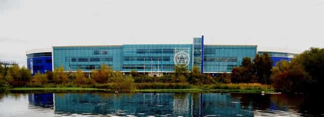 Keith Weller at King Power Stadium, modern conference venue with glass facade, networking event.