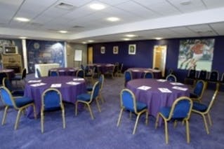 Rowley Suite at King Power Stadium with purple-draped tables for corporate events.