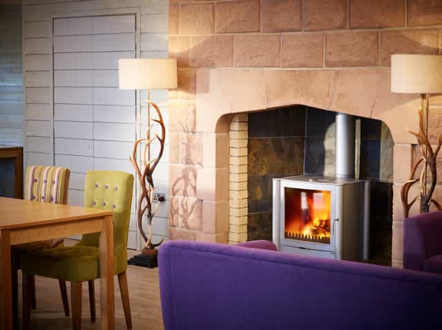 Cozy Forest Pavilion meeting space with fireplace, ideal for team-building events.