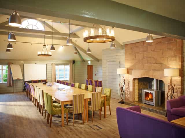 Forest Pavilion meeting space with fireplace, ideal for creative workshops and discussions.
