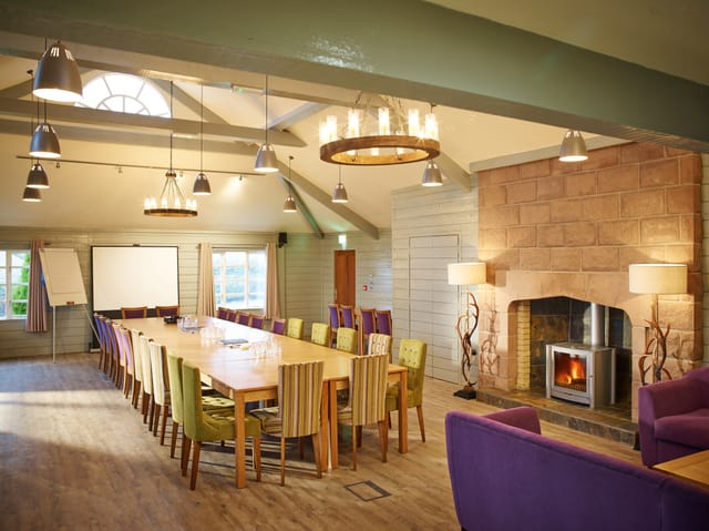 Forest Pavilion meeting space with fireplace, ideal for creative workshops and discussions.