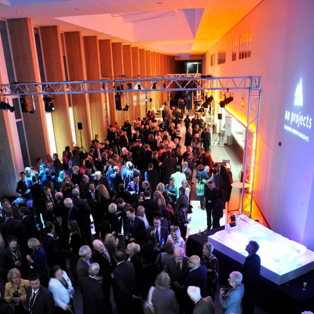 Networking event at Bournville College with ice sculpture centerpiece and vibrant atmosphere.