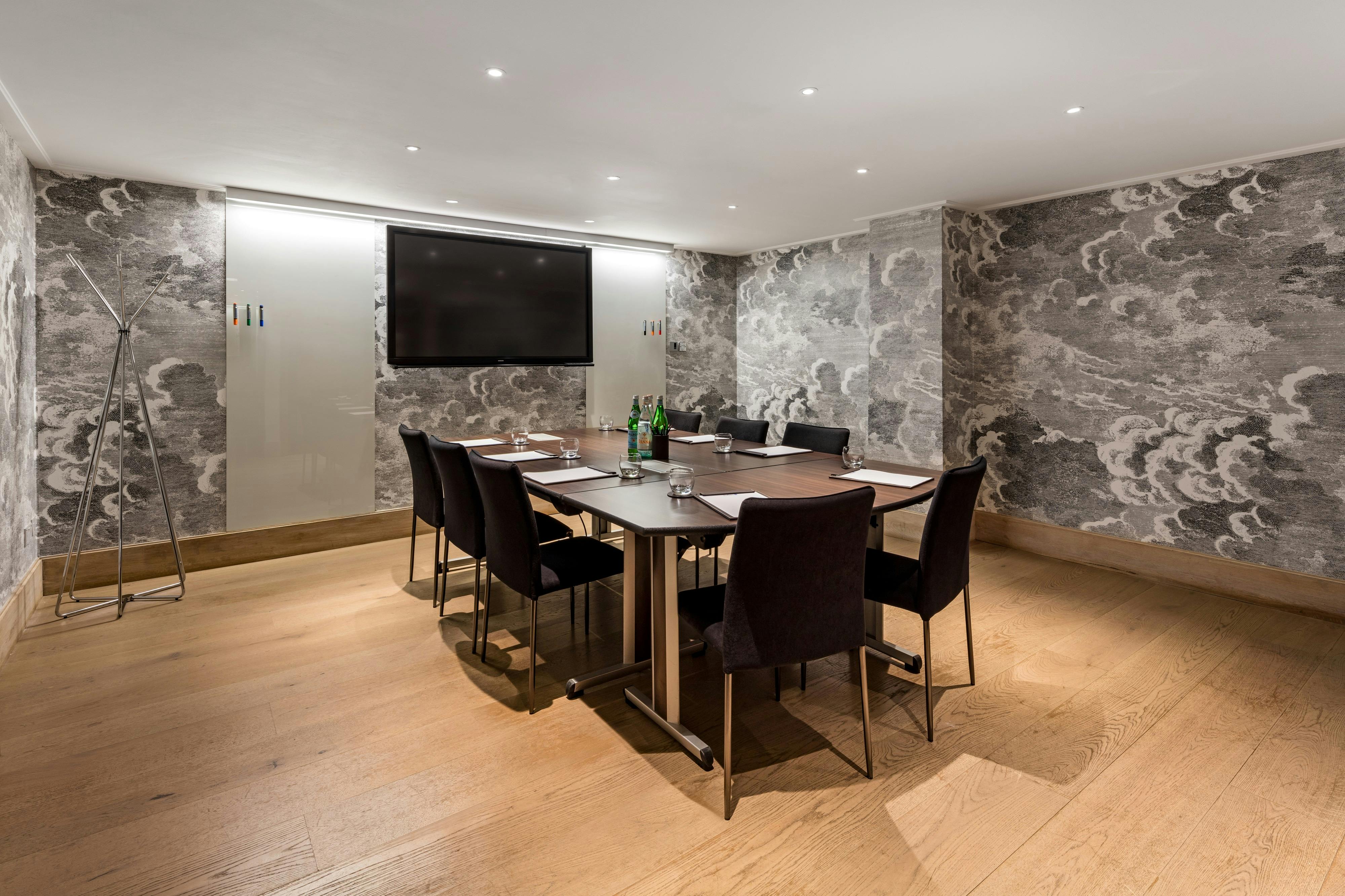 Modern meeting room in Radisson Blu Hotel, London with sleek table and wall-mounted screen.