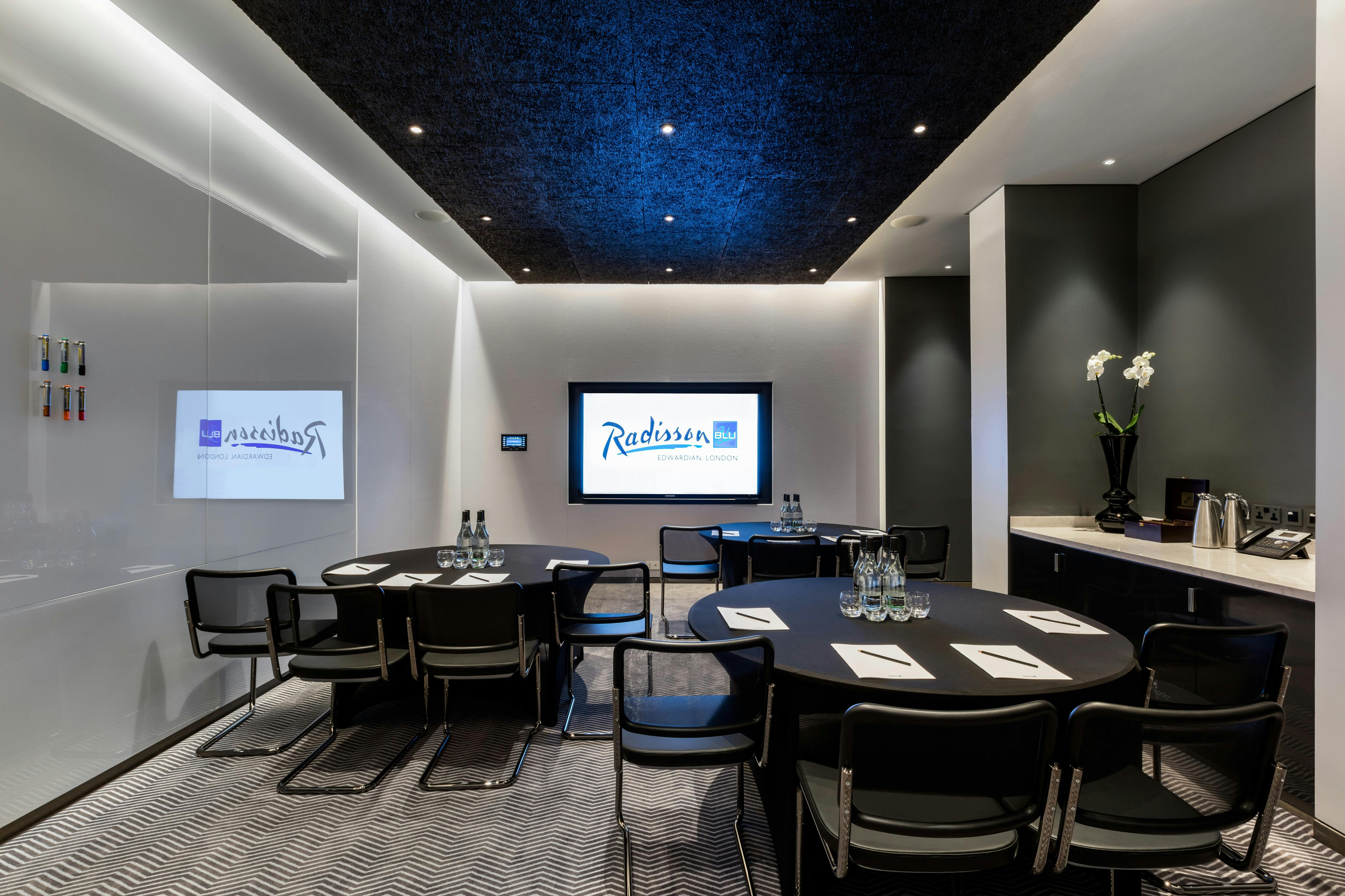 Modern meeting room at Radisson Blu London with round table, ideal for professional events.