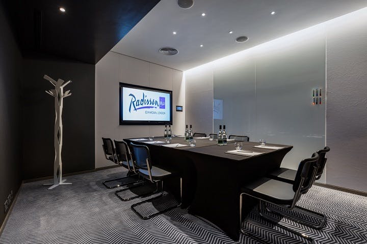 Modern meeting room with glass walls at Radisson Blu Hotel, London for professional events.