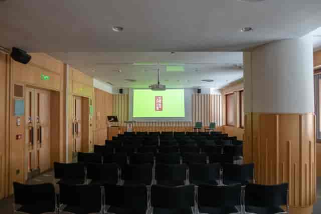 Brontë Room at British Library: modern seminar space with black chairs and green backdrop.