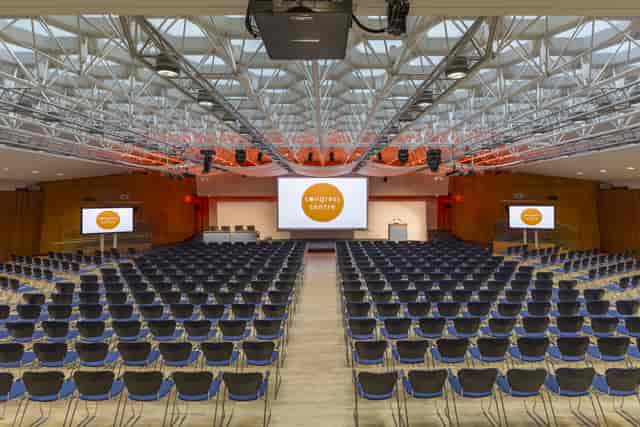 Spacious Congress Hall set for a conference with arranged chairs and screens.