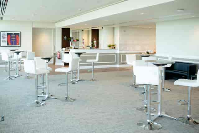 Modern event space at Epsom Downs Racecourse with high-top tables for gatherings.