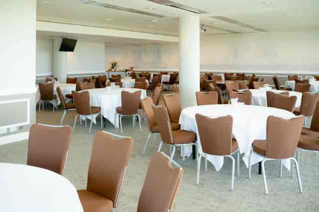 Epsom Downs Racecourse Jockey Club Room banquet setup with round tables and natural light.